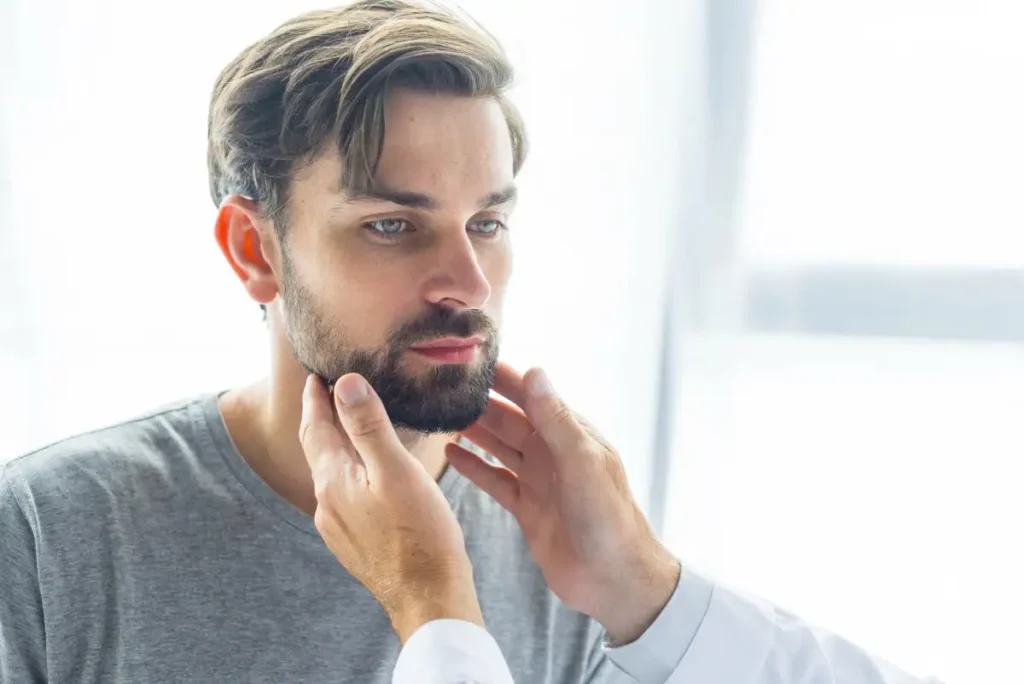 Ein Patient, der in der Klinik auf Symptome von Bartflechte untersucht wird.
